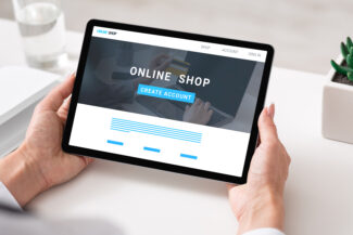 Unrecognizable businesswoman using tablet with online shop homepage on screen at office, collage. Panorama